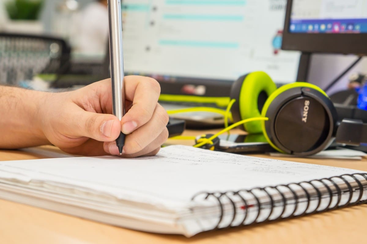 Child writing in notebook on desk