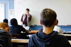 Back of child's head as he sits in classroom listening