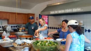 Four volunteers preparing food at volunteer event