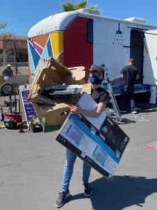 Voices for Children staff member carrying boxes at volunteer event