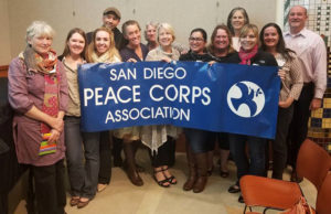Smiling volunteers holding up a banner that reads: San Diego Peace Corps Association