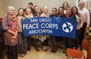 Smiling volunteers holding up a banner that reads: San Diego Peace Corps Association