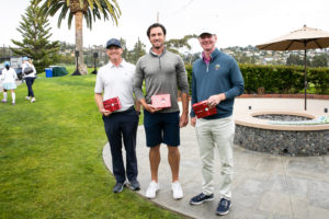 Team of golfers smiling and holding prizes