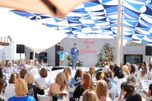 MC standing on stage of Wine Women and Shoes event