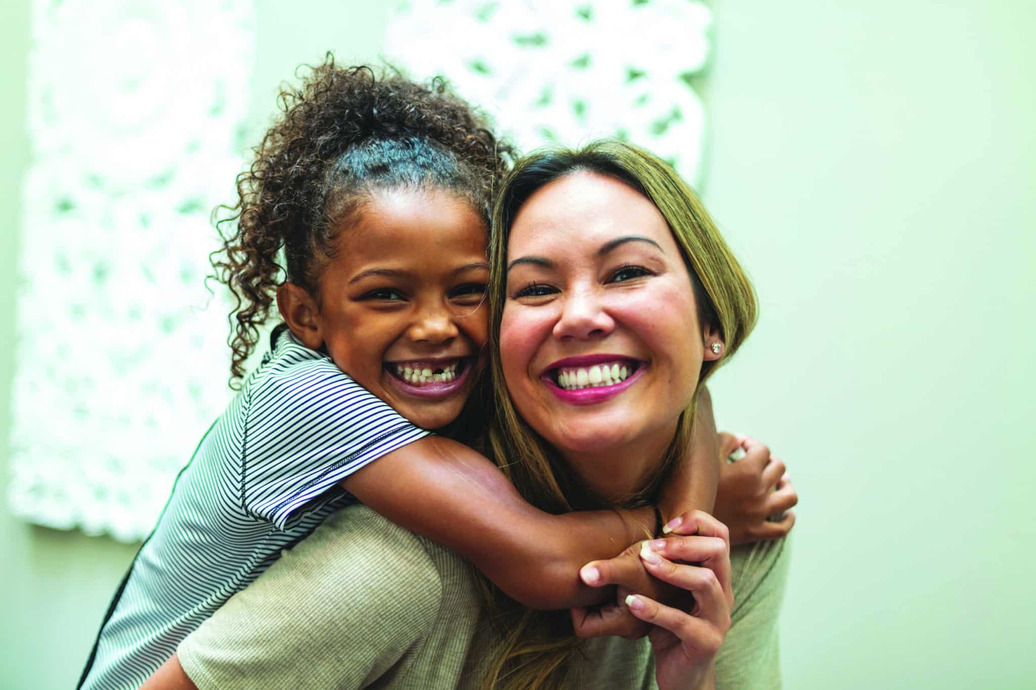 Posing playfully for portraits smiling and being silly a Chinese Mother with daughter of mixed Chinese and African American ethnicity at home indoors  (Shot with Canon 5DS 50.6mp photos professionally retouched - Lightroom / Photoshop - original size 5792 x 8688 downsampled as needed for clarity and select focus used for dramatic effect)