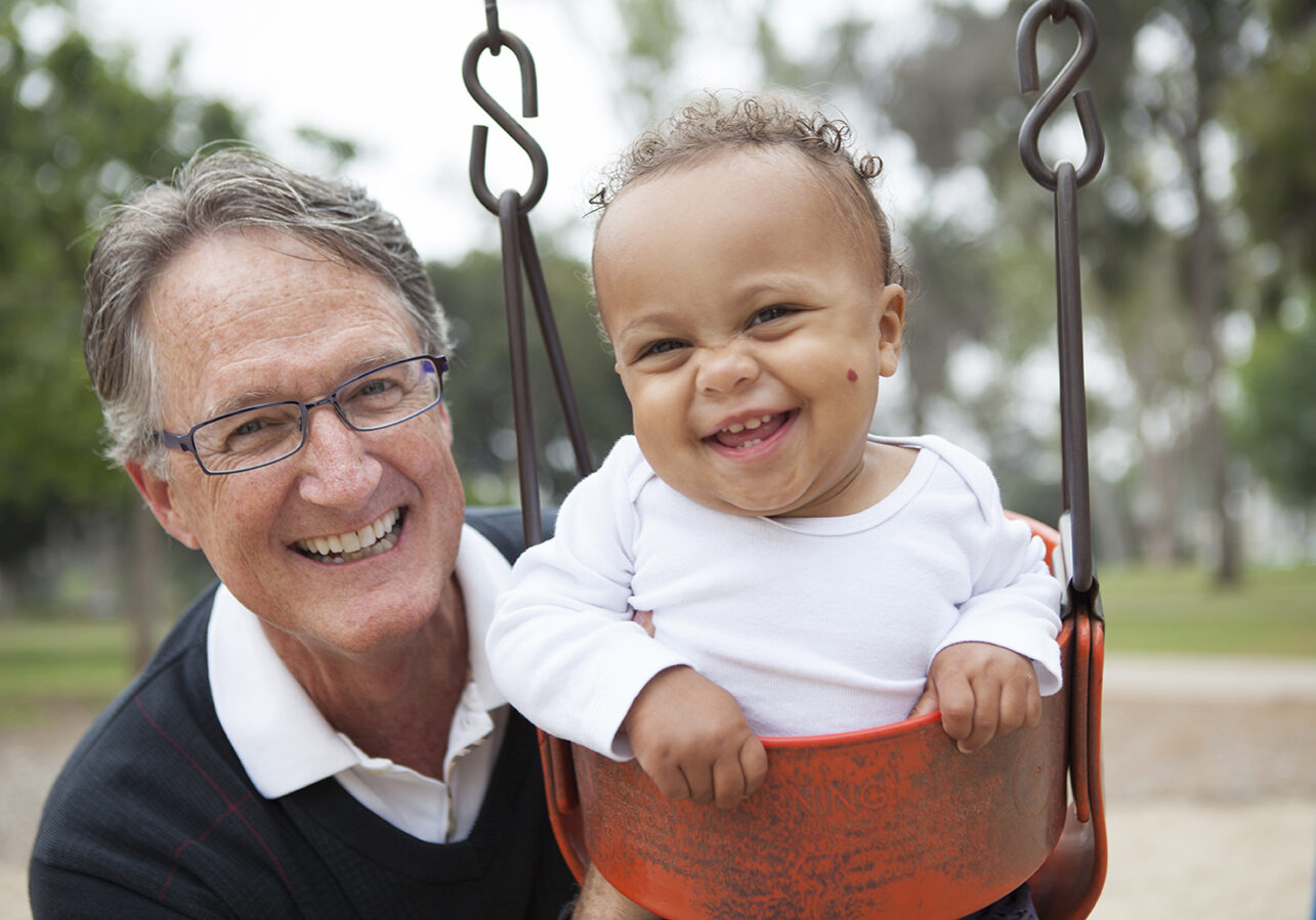 man-pushing-child-in-swing