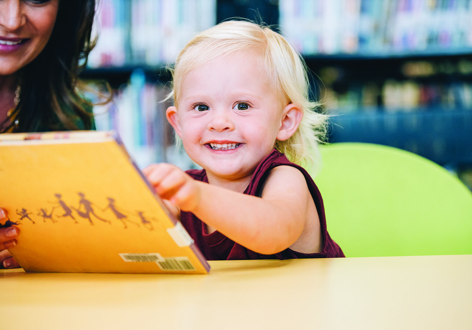 toddler-girl-sitting-at-table-in-library